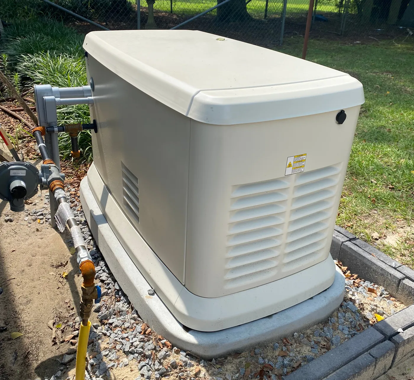 Generac home standby generator installed on a pad beside a house in eastern North Carolina